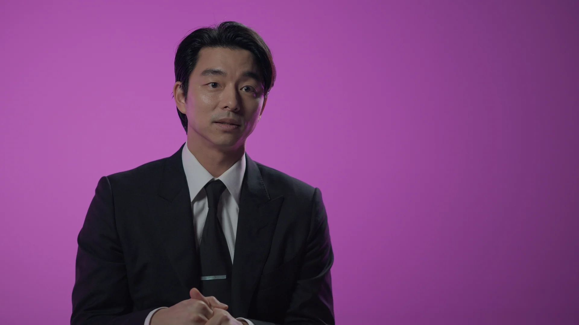 Inside Squid Game S2 — Gong Yoo interviewed against the magenta set