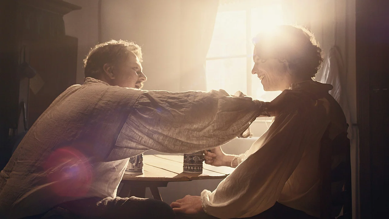 Graded frame — warm window-lit interior with natural skin tones
